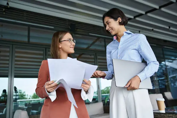 Two colleagues have a friendly conversation on a rooftop terrace at their modern office. — Stock Photo