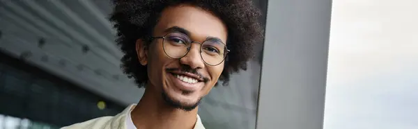 Hombre afroamericano en una moderna terraza en la azotea de la oficina, haciendo hincapié en la diversidad y el optimismo - foto de stock