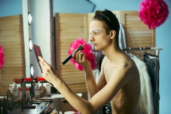 Une drag queen applique du maquillage devant un miroir en coulisses, se préparant à une performance. — Photo de stock
