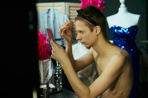 A drag queen applies makeup while looking in a mirror, preparing for a performance. — Stock Photo