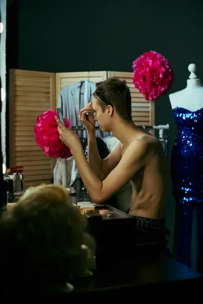 A drag queen applies makeup in a backstage dressing room, preparing for a performance. — Stock Photo