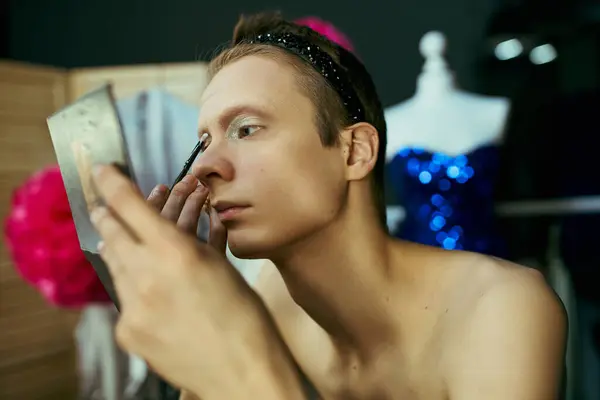 A drag queen applies makeup while looking in a mirror backstage before their performance. — Stock Photo