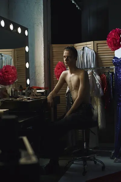 Un drag performer si siede davanti a uno specchio di vanità, in attesa della loro performance. — Foto stock