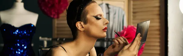 A drag queen applies lipstick while looking in a mirror, backstage before a performance. — Stock Photo