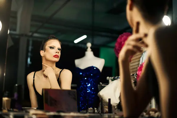 A drag queen adjusts her makeup and looks in the mirror backstage before her performance. — Stock Photo
