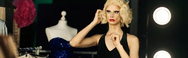 A drag queen adjusts her blonde hair and makeup, preparing for a performance in a backstage dressing room. — Stock Photo