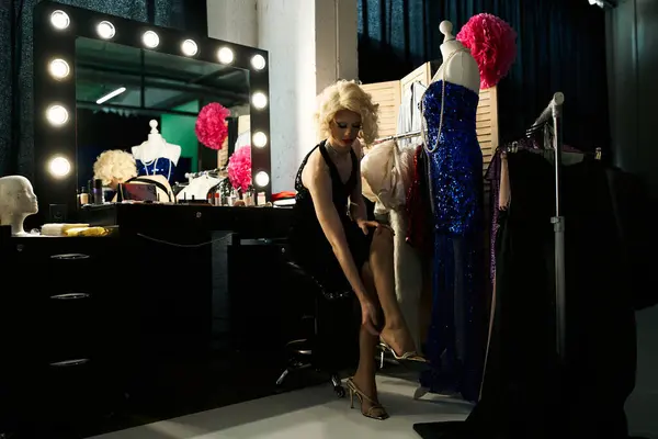 Uma drag queen ajusta seu sapato enquanto se prepara para uma performance nos bastidores. — Fotografia de Stock