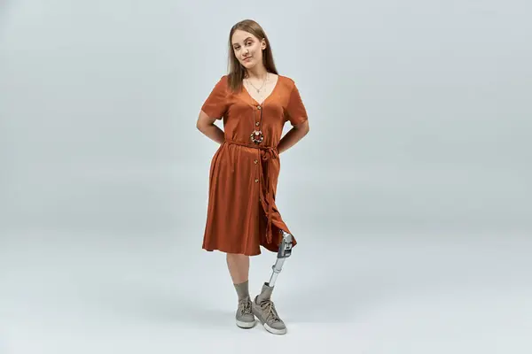 A woman with a prosthetic leg stands confidently in a studio. — Stock Photo