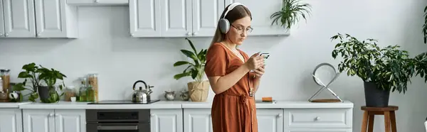 A woman listens to music while scrolling through her phone. — Stock Photo