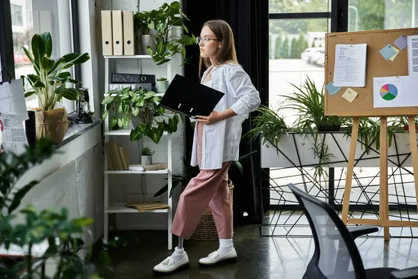 Frau mit Beinprothese blickt aus Bürofenster und hält Ordner in der Hand — Stockfoto