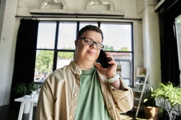 Ein junger Mann mit Down-Syndrom lächelt am Telefon. — Stockfoto