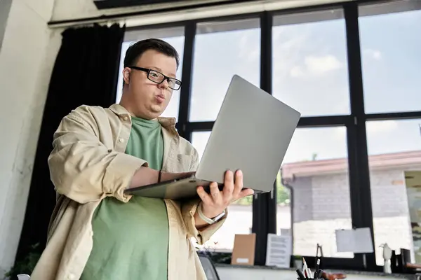 Um jovem com síndrome de Down usa um laptop em um ambiente de escritório. — Fotografia de Stock