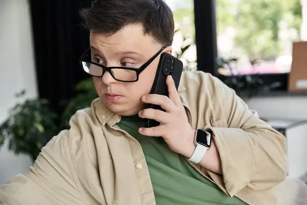 A young man with Down syndrome uses his phone. — Stock Photo