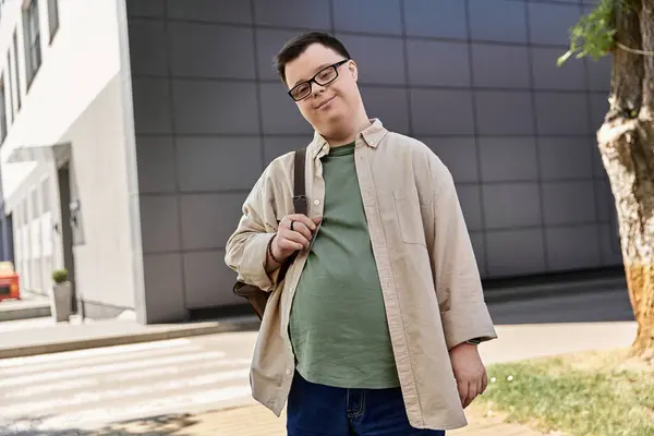 A man with Down syndrome walks down the street, smiling and carrying a bag. — Stock Photo