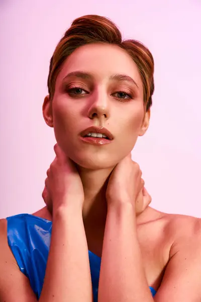 Mulher com cabelo curto, maquiagem, vestido azul, poses na frente de fundo rosa — Fotografia de Stock