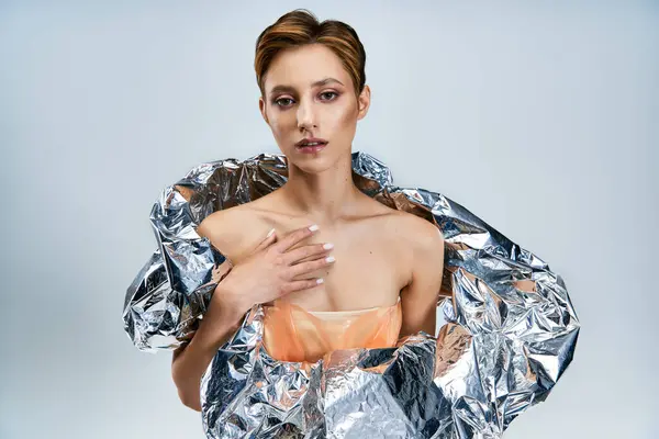 A woman in a futuristic fashion design, draped in reflective material. — Stock Photo