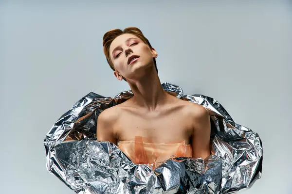 A woman draped in silver foil, a testament to sustainable fashion. — Stock Photo