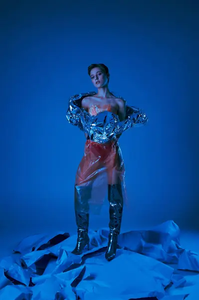 Woman in sustainable outfit on blue fabric, bathed in blue light — Stock Photo