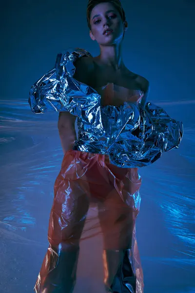 Uma mulher posa em uma roupa impressionante de prata e plástico, criando um olhar ousado e moderno. — Fotografia de Stock