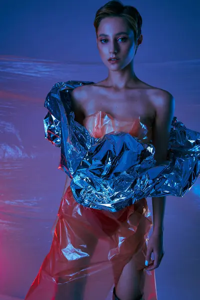 Uma mulher posa em um estúdio, vestindo uma roupa elegante feita de materiais plásticos reaproveitados. — Fotografia de Stock