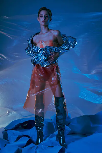 A woman stands in a futuristic setting, clad in sustainable, metallic fashion. — Stock Photo