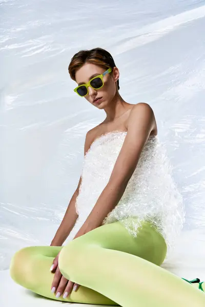 Uma mulher senta-se em meio a plástico bolha, vestindo uma roupa de moda sustentável. — Fotografia de Stock