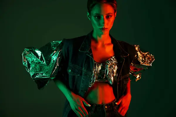 Woman in studio wearing silver top and denim jacket, lit with green and red — Stock Photo