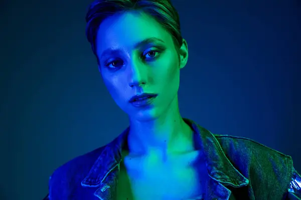 A woman's face illuminated by vibrant blue and green lights. — Stock Photo
