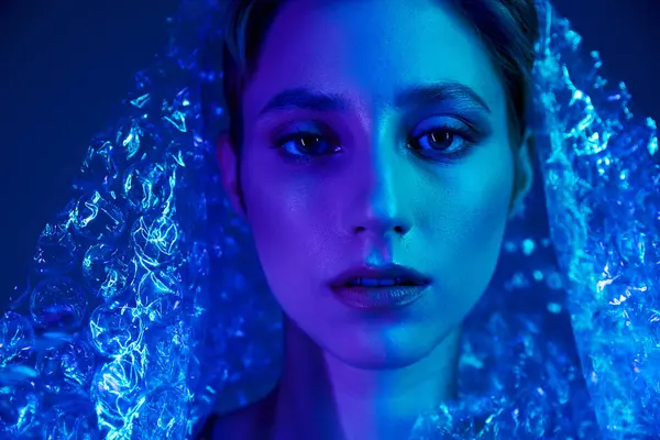 A woman's face is illuminated by a blue light, her gaze captivating. — Stock Photo