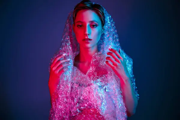Mulher com bolha envoltório-coberto corpo iluminado por luz vermelha e azul — Fotografia de Stock