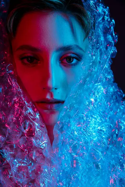 A woman's face is illuminated by pink and blue light, obscured by a translucent, bubble-like fabric. — Stock Photo
