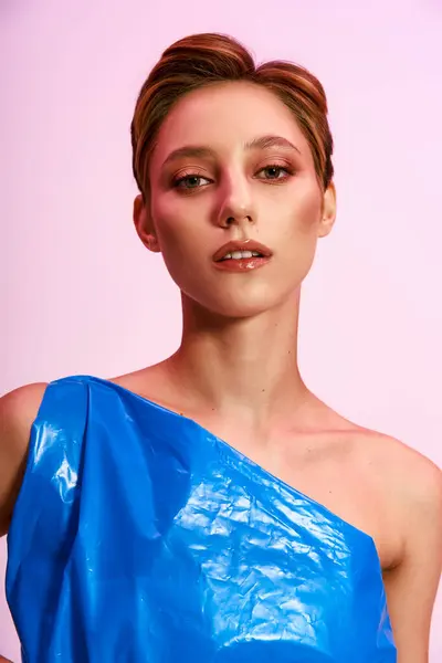 A woman poses in a stylish, blue, one-shoulder dress made from recycled plastic. — Stock Photo
