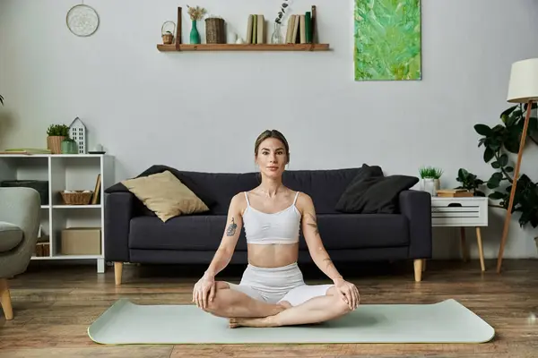 A young woman with vitiligo practices yoga in a comfortable apartment setting, focusing on her inner peace and mental well-being. — Stock Photo
