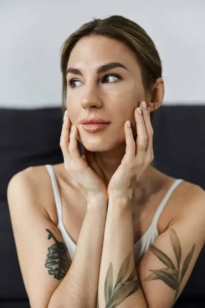 A young woman with vitiligo sits in a modern apartment, her hands resting on her face as she meditates. — Stock Photo
