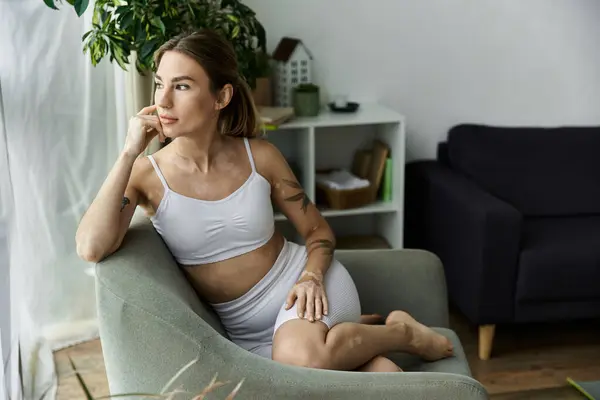 Eine junge Frau mit Vitiligo sitzt in einer modernen Wohnung und übt Achtsamkeit. — Stockfoto