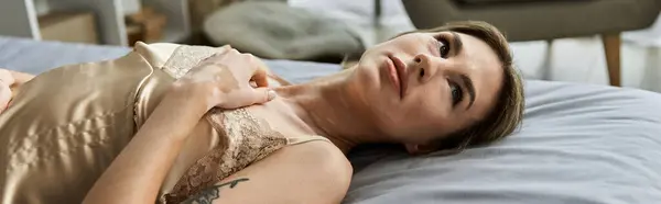 A young woman with vitiligo and a tattoo lies on her bed in a modern apartment bedroom, taking a moment to relax. — Stock Photo