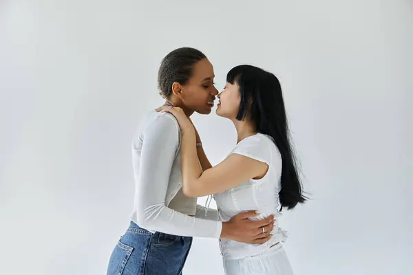 Two young women in love share a tender moment against a white backdrop. — Stock Photo