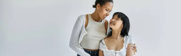 An interracial lesbian couple share a tender moment, their faces lit with love. — Stock Photo