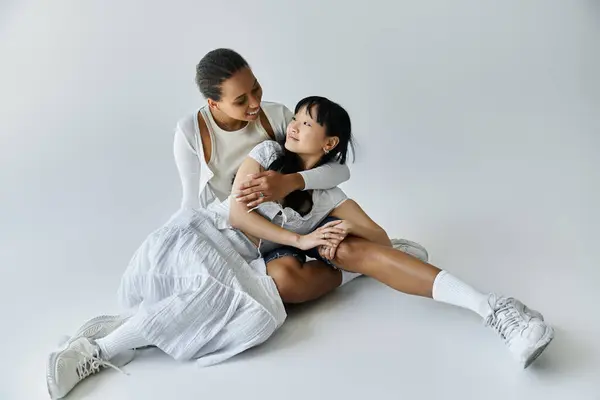 An interracial couple shares a tender moment, embracing each other on a simple backdrop. — Stock Photo