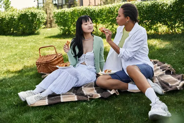 A lesbian couple enjoys a sunny day, picnicking in the park. — Stock Photo