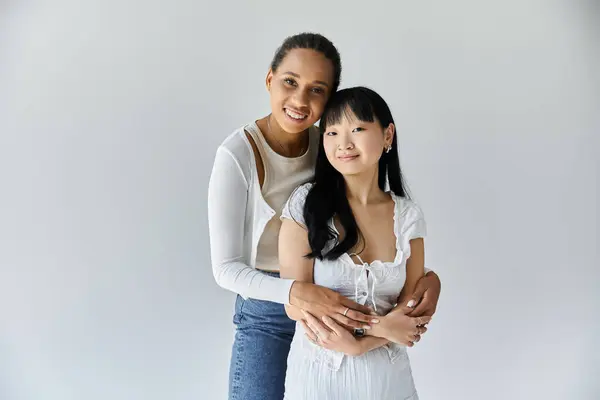 Two young women, one Black and one Asian, stand close — Stock Photo