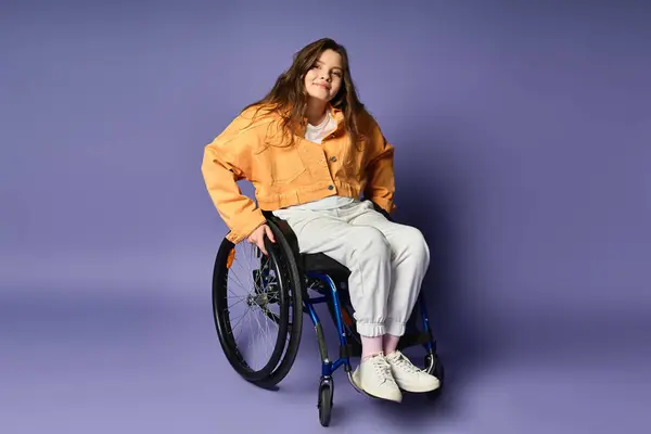 Disabled girl in 20s sitting in wheelchair on purple backdrop — Stock Photo