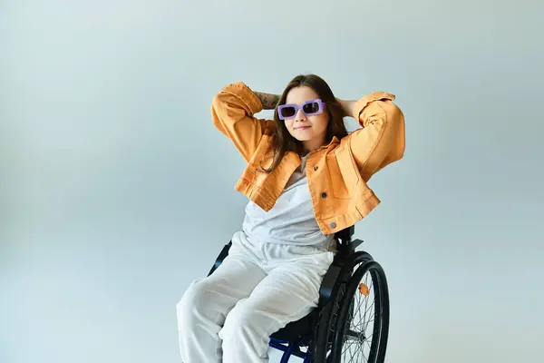 A young woman in a wheelchair with a fashionable outfit, sunglasses, and a confident smile. — Stock Photo
