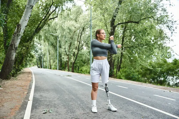 Молодая женщина в спортивной одежде активно занимается на открытом воздухе, обнимает фитнес с решимостью. — стоковое фото