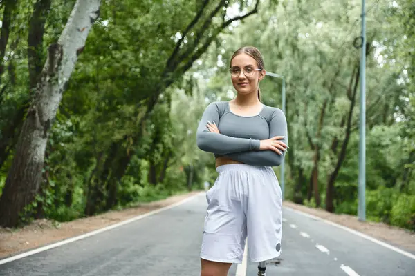 A young woman in sportswear confidently embraces her outdoor workout, showcasing strength. — Stock Photo