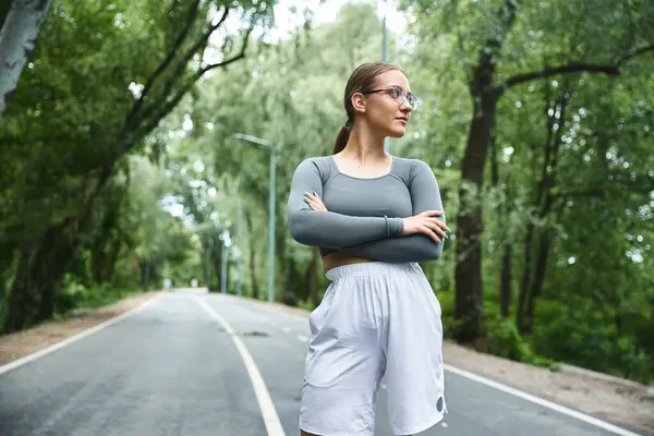 Una giovane donna si allena con sicurezza all'aperto, nel verde lussureggiante. — Foto stock