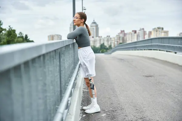 A young woman confidently enjoys the outdoors, embracing fitness and freedom with her prosthetic leg. — Stock Photo