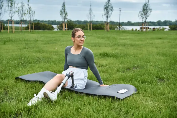 A determined young woman in sportswear embraces her fitness routine while basking in nature. — Stock Photo