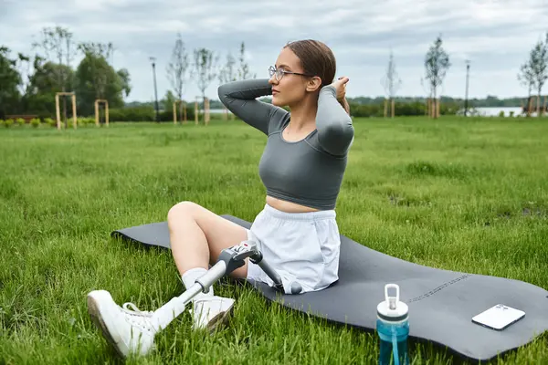 Eine entschlossene junge Frau mit Beinprothese streckt sich im Freien und genießt ihr Workout an der frischen Luft. — Stockfoto