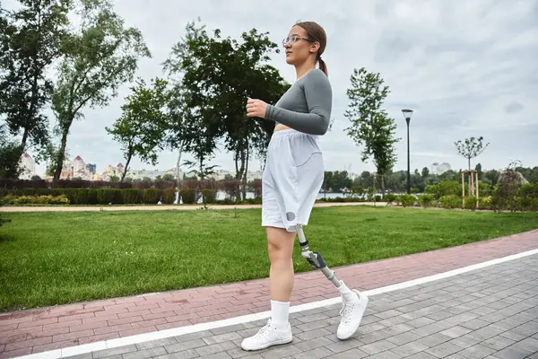 Una giovane donna si lancia fiduciosa lungo un percorso panoramico, abbracciando il fitness e l'aria aperta. — Foto stock